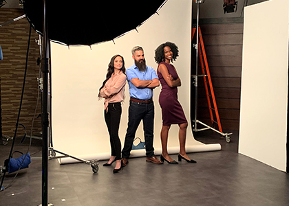 RSM professionals stand in front of a backdrop, in a studio, getting their picture taken